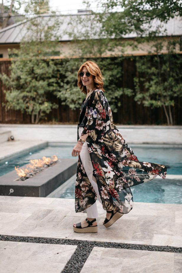 woman wearing black top, white pants, floral kimono and platform sandals at the poolside