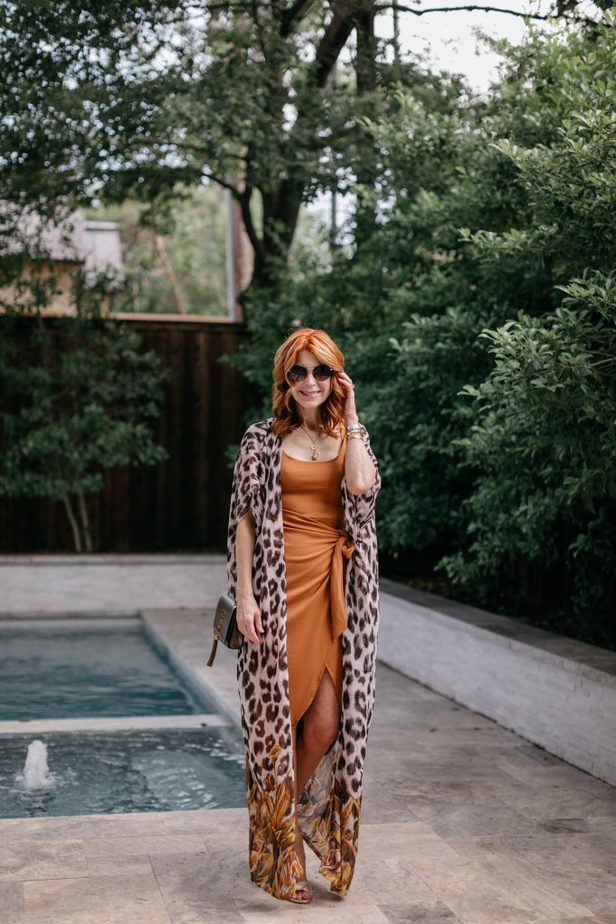 woman wearing date night dress with animal print cover up near the pool