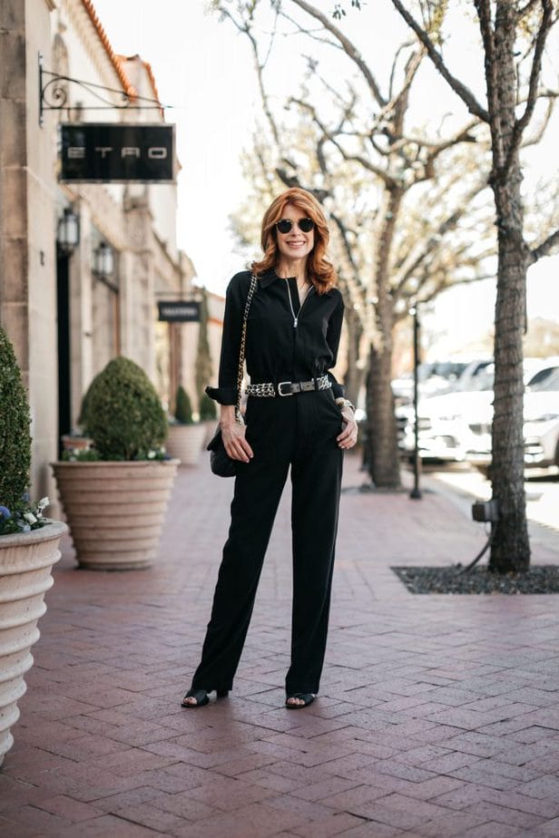 woman standing and wearing all black overalls   