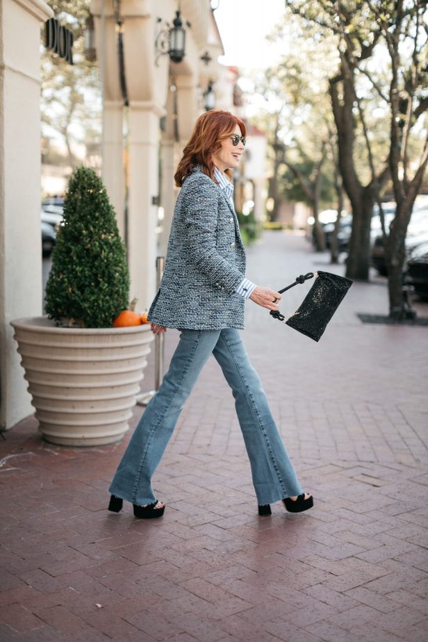 Dallas over 50 fashion influencer wearing raw hem flare jeans with tweed blazer.